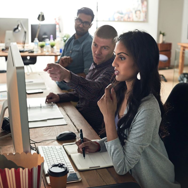 Cropped shot of a group of businesspeople discussing something on a computer in an office