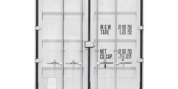 Back view of closed white freight container with text.