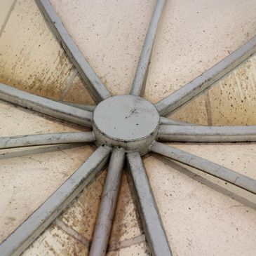 Close-up of a dirty, geometric ceiling structure with radial beams.