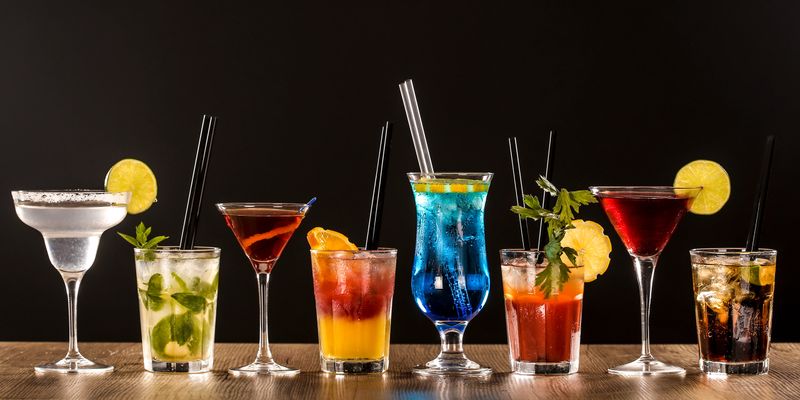 Colorful cocktails on bar counter - Margarita, Mojito, Blue Lagoon, Bloody Mary, Tequila Sunrise, Rob Roy and Cuba Libre.