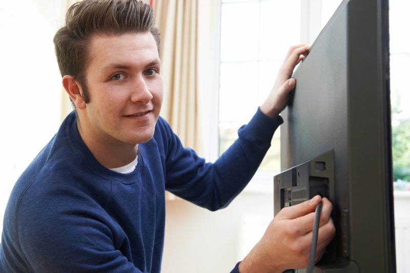 Television Engineer Installing New Television At Home