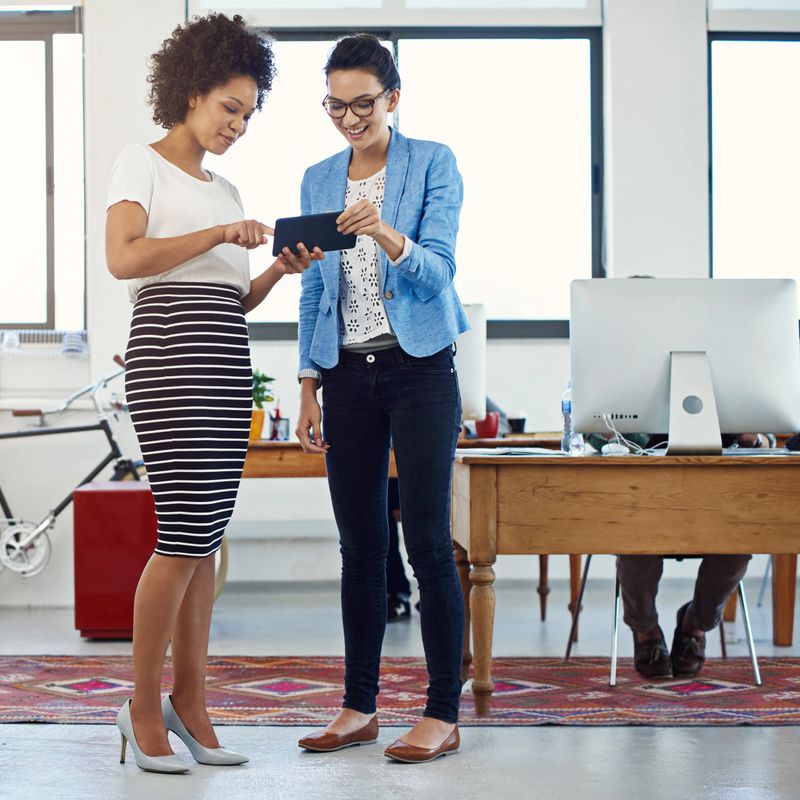 Shot of two young designers talking together over a digital tablet in an office