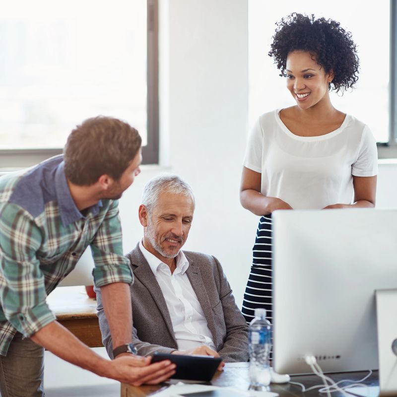Shot of a group of designers talking together over a digital tablet in an office