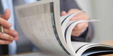 Person in business attire flipping through a report or document.