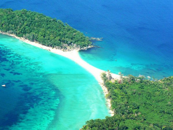 Aerial view of a tropical island with turquoise waters and dense greenery.