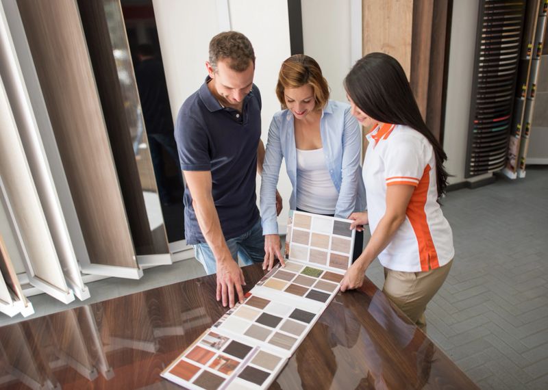 Couple at a floor store looking at wood samples - home improvement concepts