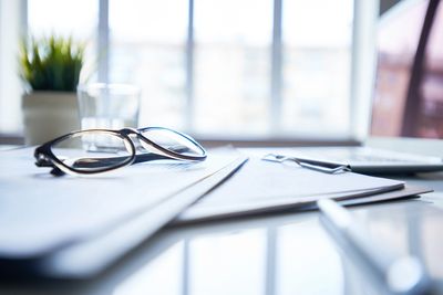 A desk with paperwork and glasses