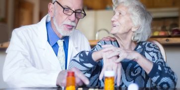 Doctor consulting with elderly woman about medication.