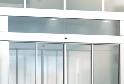 Modern glass entrance doors with sleek metal handles in a bright interior.