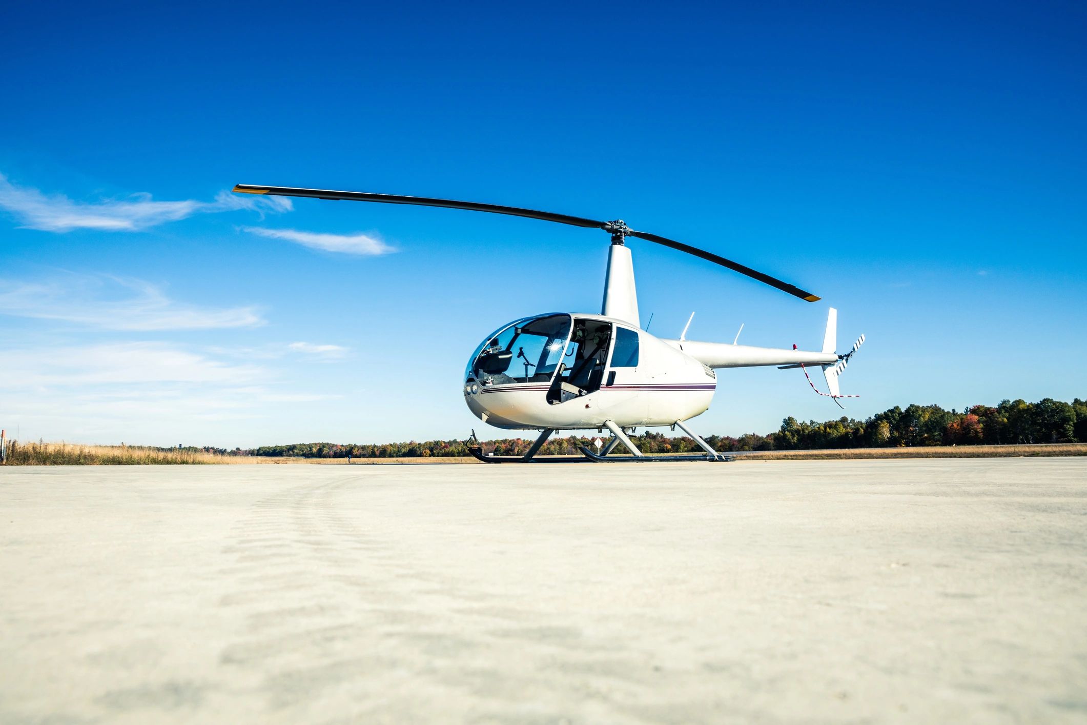 White helicopter on a concrete runway.