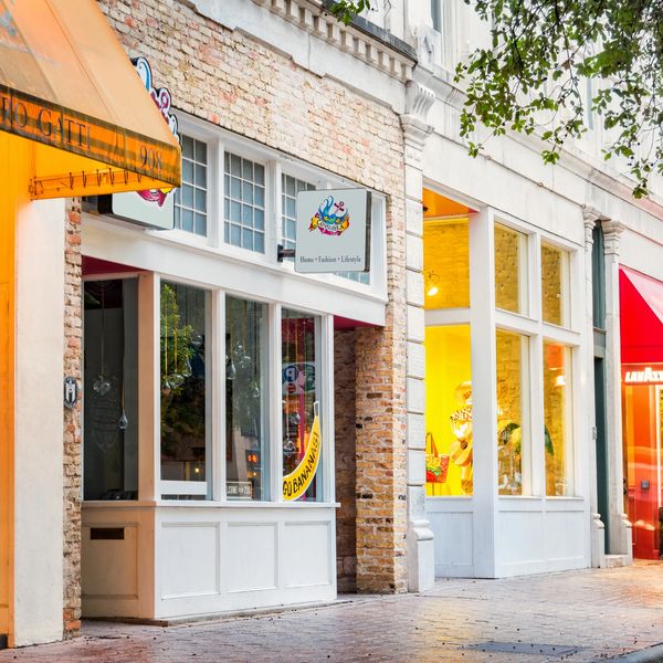 Charming street with colorful storefronts and awnings on a sunny day.