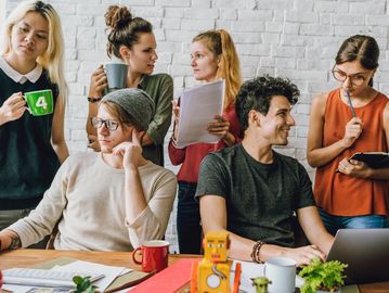 A diverse group of young adults collaborating in a casual workspace.
