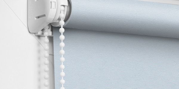 Close-up of a blue roller blind with a white bead chain mechanism.