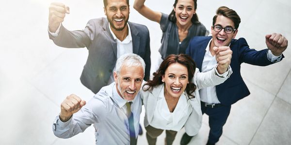 Diverse group of professionals applauding in a modern office setting.