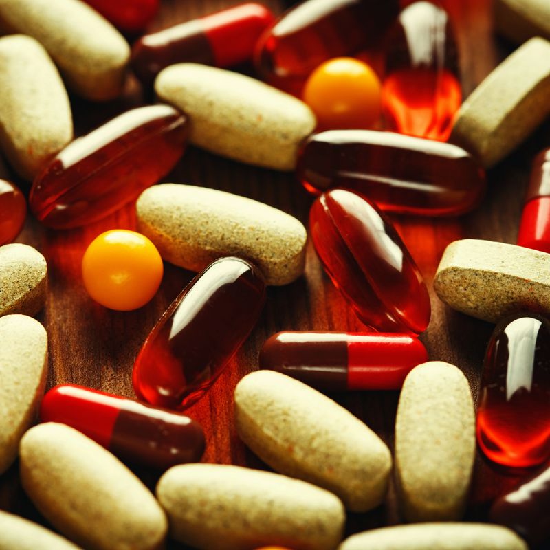 Organic dietary treatment, vitamin capsules on wooden background, selective focus, close-up