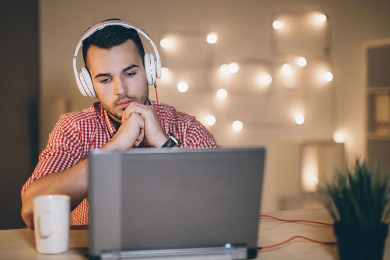 Young man listening music in dark room
