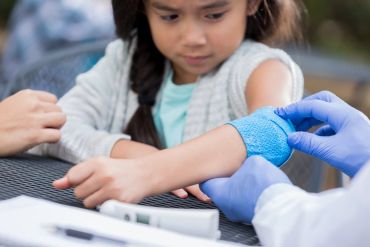 A child receiving a medical bandage on arm.