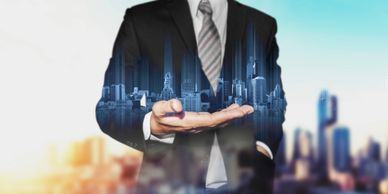 Businessman holding a holographic cityscape in his hand.