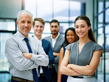 Confident diverse business team posing with crossed arms in a modern office.