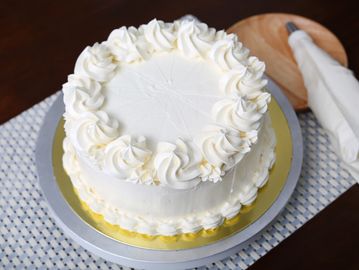 White frosted cake with cream swirls.