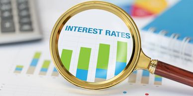 Magnifying glass highlighting interest rates on a financial chart.