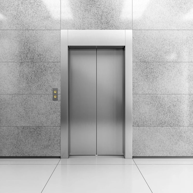 Modern steel elevator with closed doors in contemporary lobby. 3D illustration.