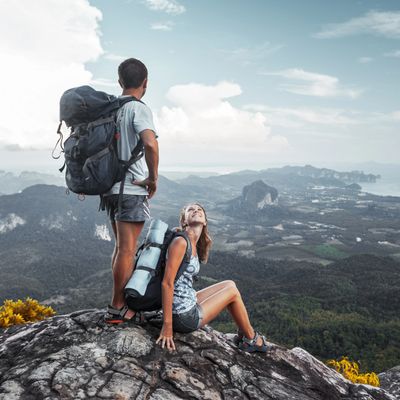 Two hikers enjoying a breathtaking mountain view from the summit.
