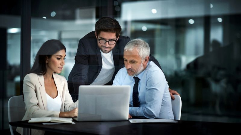Shot of colleagues using a laptop together at work