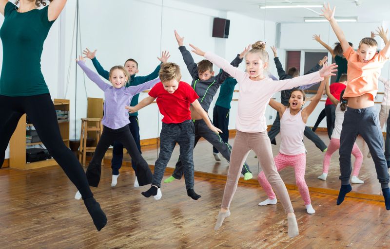Ordinary boys and girls studying contemp dance in dancing studio