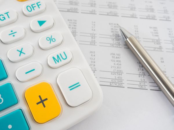 Close-up of a calculator and pen on financial documents.