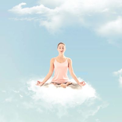 Woman meditating while sitting on a cloud, surrounded by a peaceful sky.
