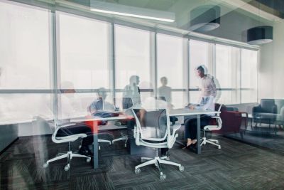 People collaborating in a modern office meeting room with large windows.