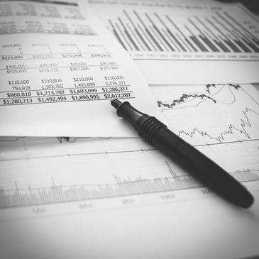 Pen on financial documents with charts and figures.