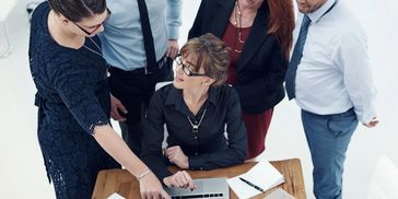 Business team discussing around a laptop.
