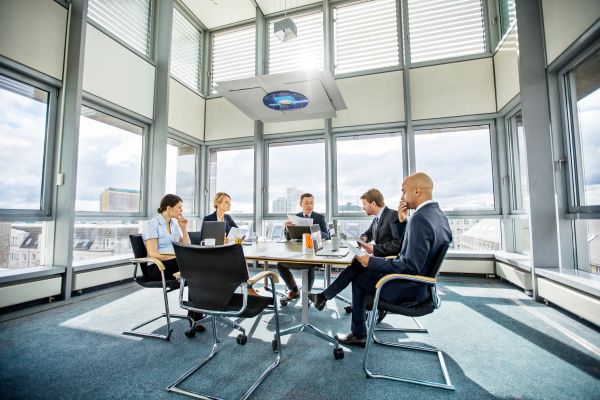 Business meeting with five professionals in a bright office.
