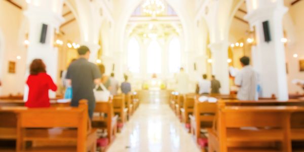 People standing inside a brightly lit church.