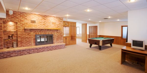 finished basement with pool table, and brick fireplace with walkout to back of home. 