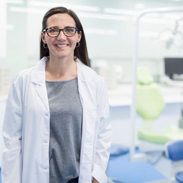 Smiling female doctor in a white lab coat in a medical office.