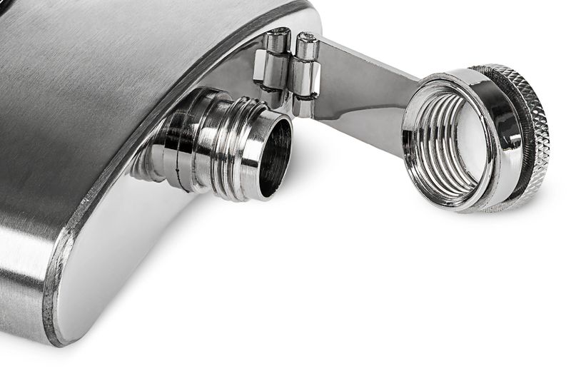 Closeup of stainless open hip flask lying isolated on white background