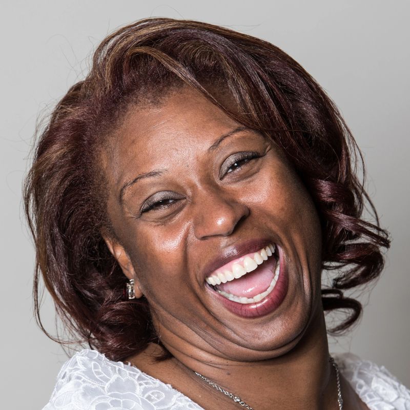Mature black woman laughing on gray background