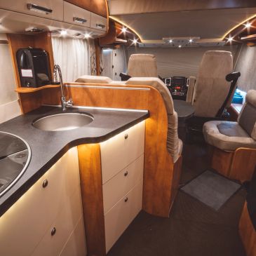 Cozy RV interior with kitchen and seating.