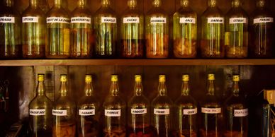Shelf with various labeled bottles containing herbs and spices.