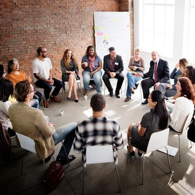 Diverse group in a casual circle discussion in a bright room.