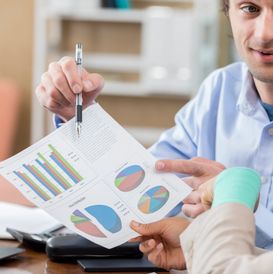 Person explaining charts with pen.
