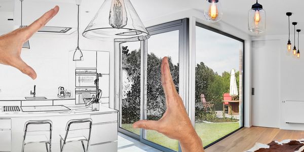 Hands framing a modern kitchen transitioning from sketch to reality.