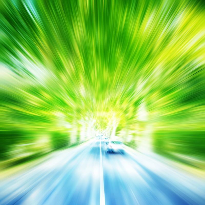 Car in motion blur driving on country road.