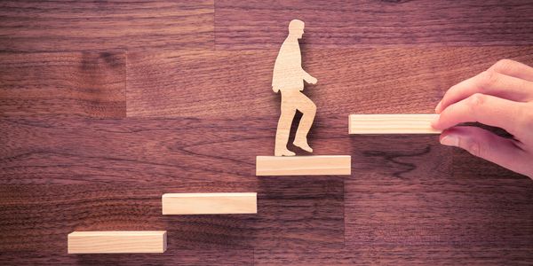 Person climbing stairs symbolizing career progression and professional growth