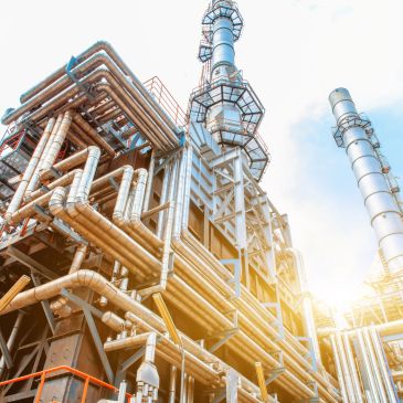 Industrial plant with pipes and towers under sunlight.