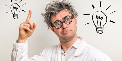 The image is of an inventor with a typically nerdy appearance and lightbulbs popping up around the h