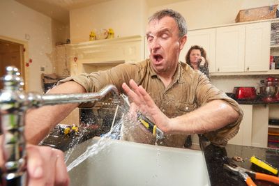 Homeowner fixing a leaking pipe